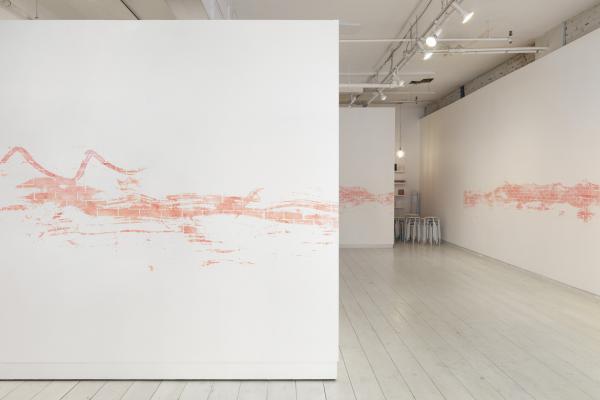 installation view of a long stencilled drawing in pink chalk