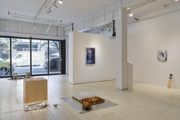 installation view of multiple sculptures and wall works in a white gallery.