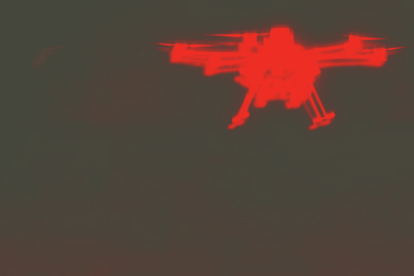 A dark grey-green background with a blurry red silhouette of a quadcopter drone. 
