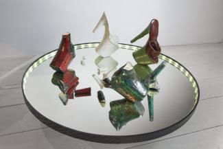 installation view of ceramics shoes on a mirror platform installed in a gallery