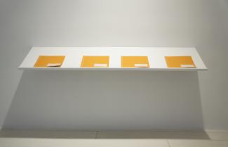 four logbooks on a white shelf