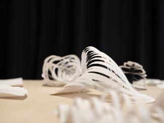 a table topped with cut and folded paper works