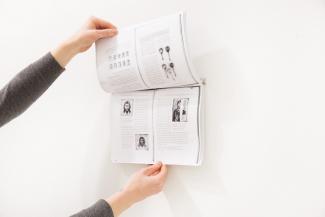 hands holding open a paper book