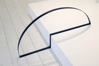 metal sculpture made from bands of steel on a low plinth