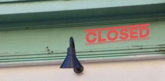 pale green architectural detail outside of Access Gallery with a black lamp, over the image is stamped "CLOSED!"