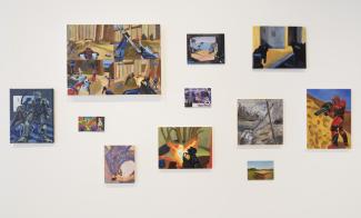 A collage of colourful paintings displayed on a white wall depicts various scenes with soldiers, futuristic robots, and dynamic landscapes. There are 11 in total.