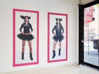 Two side-by-side portraits of figures in matching outfits, featuring a black tutu, matching top, and boots, against a white background with magenta borders.