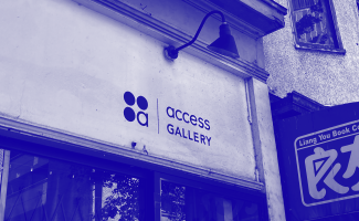 A duotone photo in royal blue of the Access Gallery logo painted on the storefront of the building. 