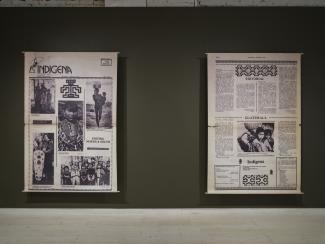 Two large canvas prints stretch from floor to ceiling in the gallery. They show enlargements of a newspaper titled Indígena: News From Indian America.